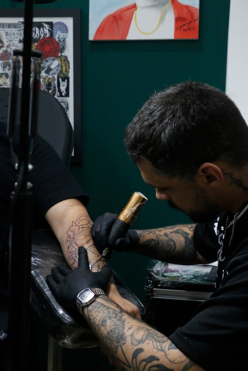 Raphael tatuando um antebraço no estúdio